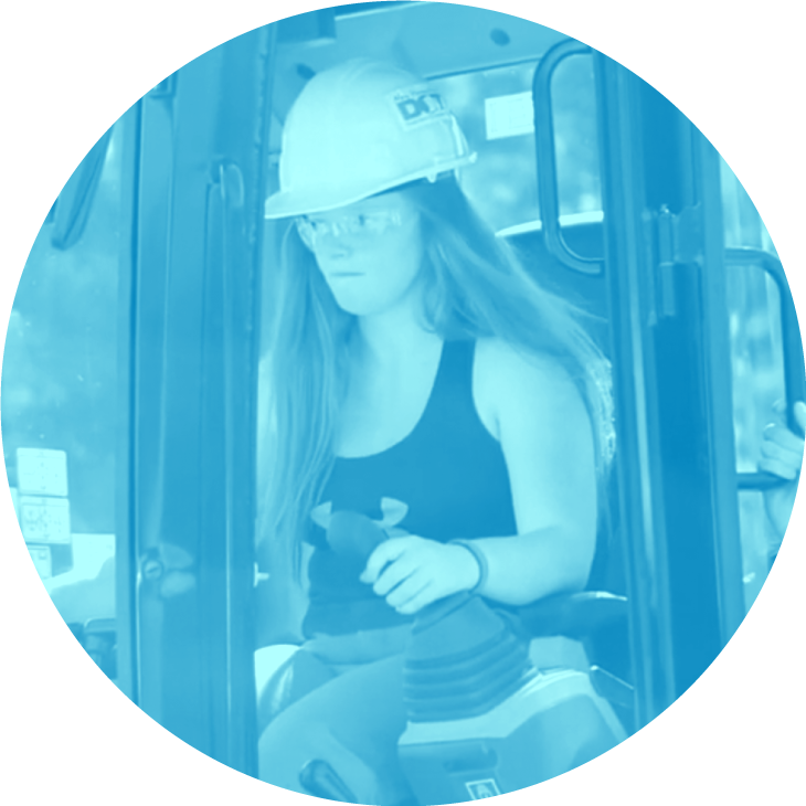 Woman in a hard hat operating heavy machinery, seen through a blue-tinted filter.
